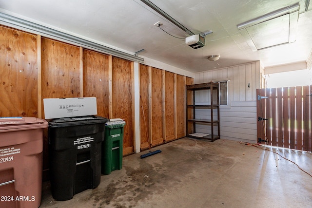 garage with a garage door opener and wooden walls