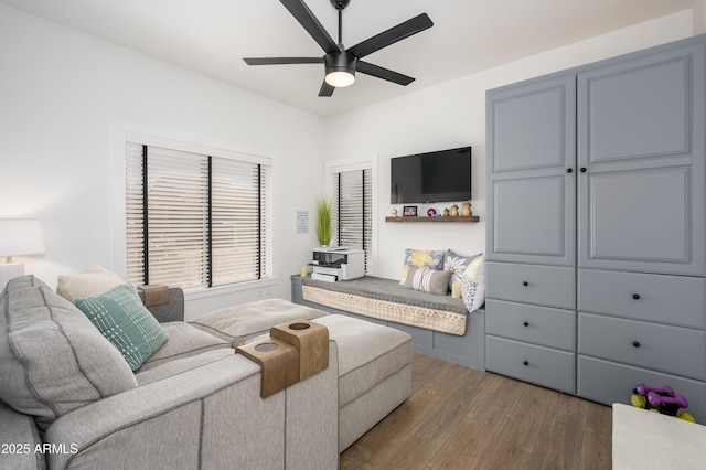 living area with a ceiling fan and wood finished floors