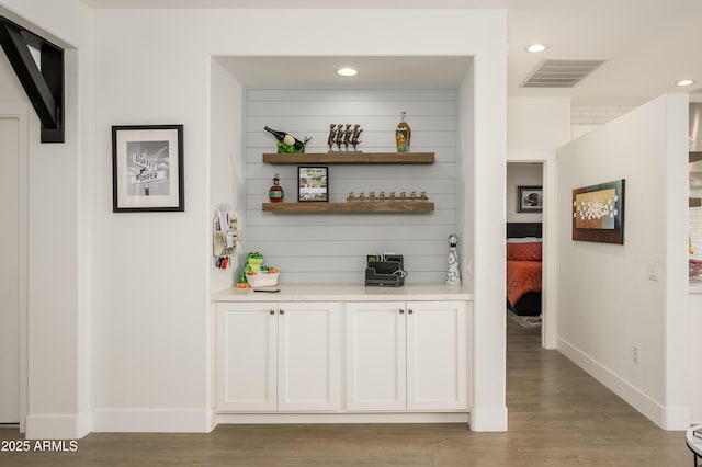 bar with light wood-type flooring, visible vents, baseboards, and recessed lighting