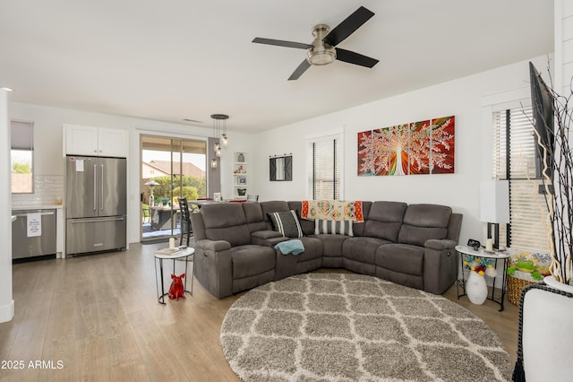 living area with light wood-type flooring and ceiling fan