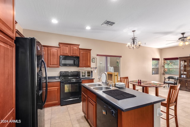 kitchen with a kitchen island with sink, sink, black appliances, light tile patterned floors, and ceiling fan with notable chandelier