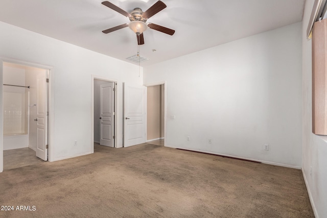 unfurnished bedroom featuring connected bathroom, carpet flooring, and ceiling fan