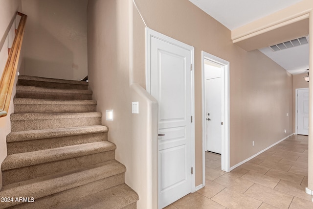 stairway with tile patterned flooring