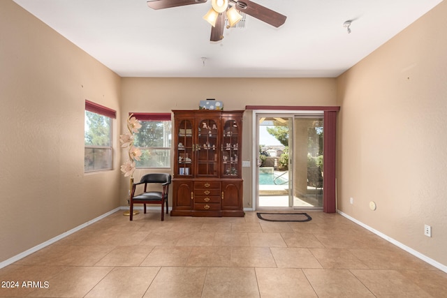 living area featuring light tile patterned floors and ceiling fan