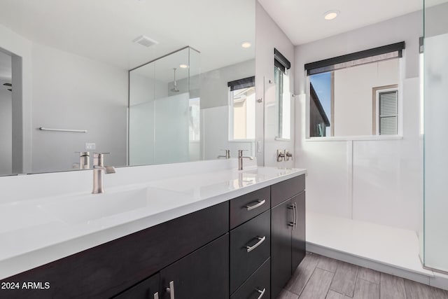 bathroom with vanity and a tile shower