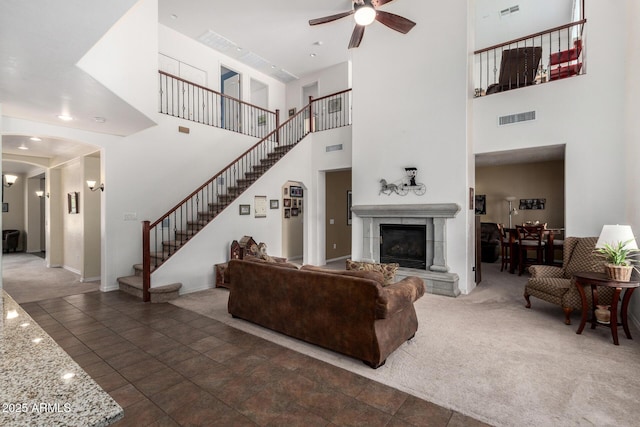 4125 W Lydia Ln, Phoenix, AZ 85041 - living area with stairs, a tiled fireplace, carpet flooring, visible vents, and ceiling fan