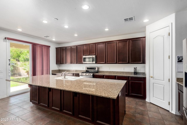 4125 W Lydia Ln, Phoenix, AZ 85041 - kitchen with recessed lighting, stainless steel appliances, an island with sink, visible vents, and light stone countertops