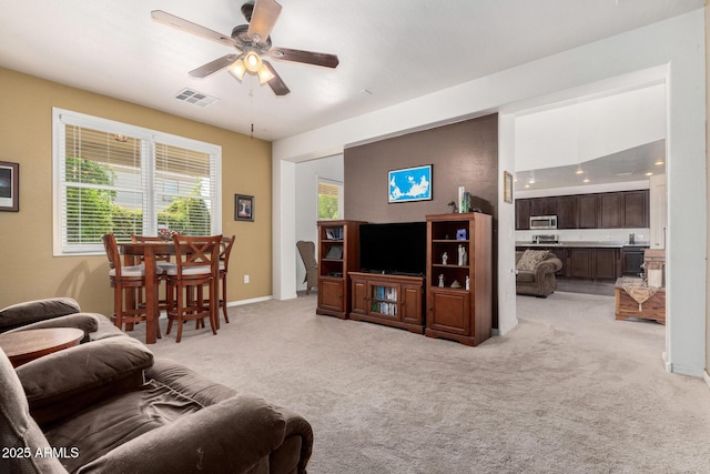 4125 W Lydia Ln, Phoenix, AZ 85041 - living area featuring light colored carpet, visible vents, baseboards, and a ceiling fan