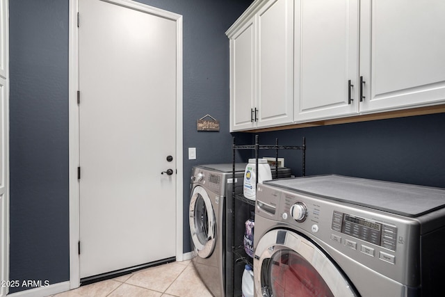 laundry area with cabinets, washing machine and dryer, and light tile patterned flooring