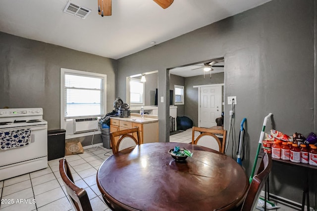 dining area with light tile patterned floors, visible vents, and a ceiling fan