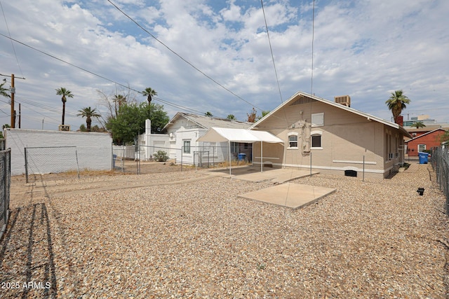 rear view of property featuring a patio area and fence