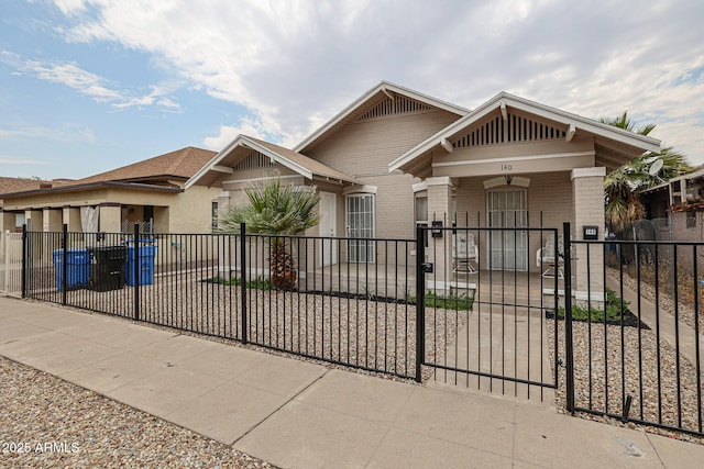 view of front of home featuring a fenced front yard, a gate, and brick siding