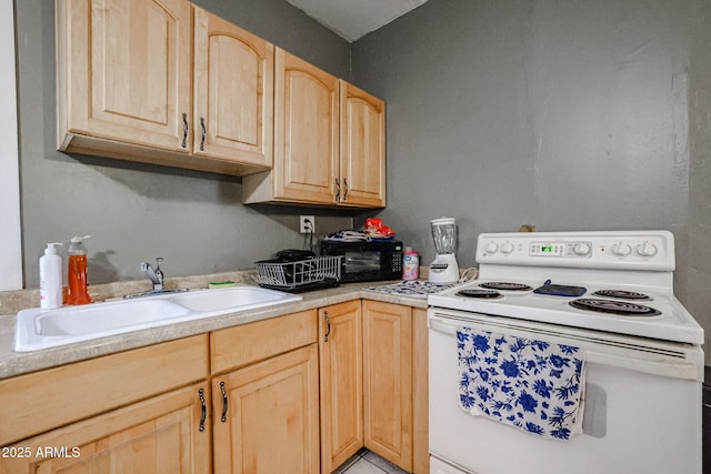 kitchen featuring white electric stove, light countertops, a sink, and light brown cabinets