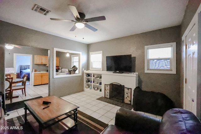 living room with light tile patterned floors, a wealth of natural light, and ceiling fan