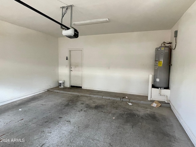 garage featuring baseboards, electric water heater, and a garage door opener