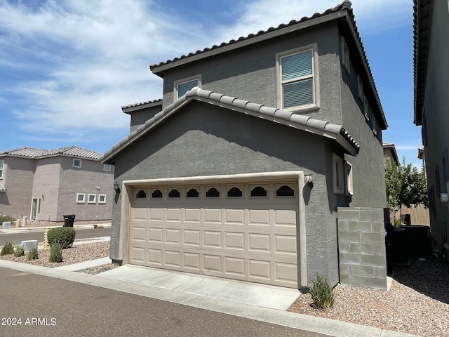 view of front of home featuring a garage, a tile roof, and stucco siding