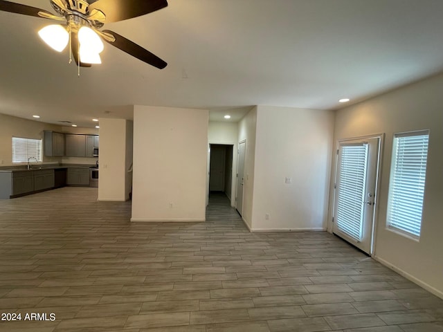 unfurnished living room with sink and ceiling fan