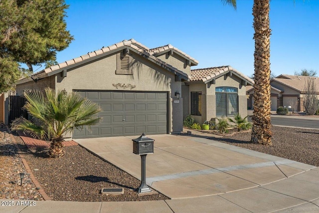 mediterranean / spanish home with a garage, a tile roof, driveway, and stucco siding