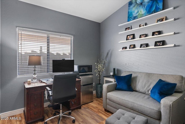 office with baseboards, vaulted ceiling, and wood finished floors