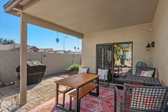 view of patio / terrace with fence, grilling area, and outdoor dining space