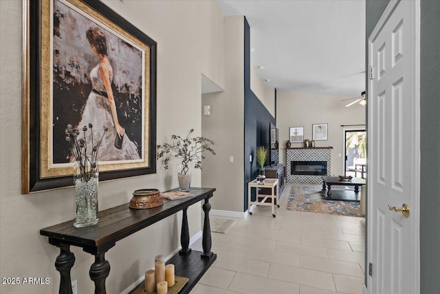 corridor with vaulted ceiling, tile patterned floors, and baseboards