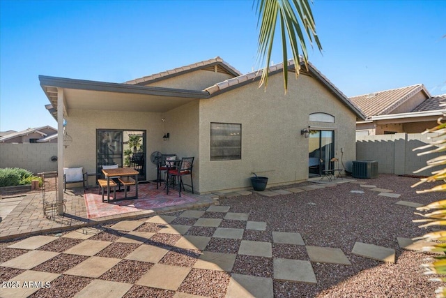 rear view of property featuring a tiled roof, fence, cooling unit, a patio area, and stucco siding