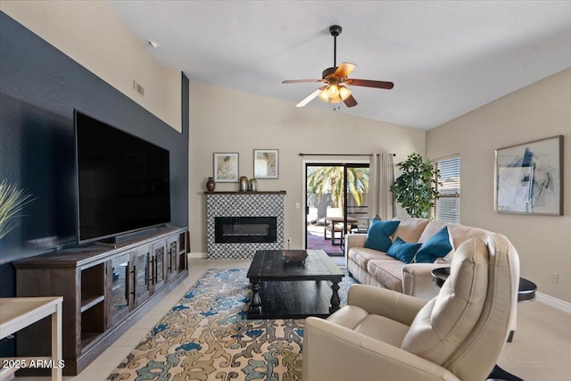 living area with a fireplace, lofted ceiling, visible vents, a ceiling fan, and baseboards