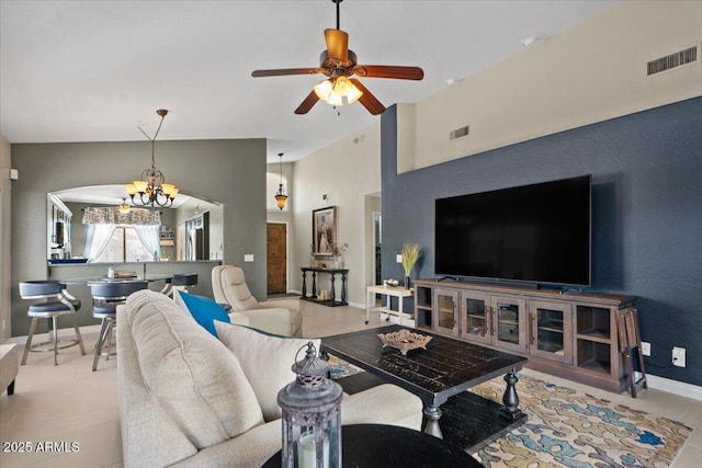 living room with high vaulted ceiling, baseboards, visible vents, and ceiling fan with notable chandelier