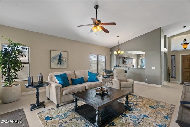 living room featuring light tile patterned floors, baseboards, vaulted ceiling, and ceiling fan with notable chandelier