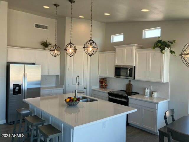 kitchen featuring white cabinetry, a kitchen island with sink, sink, and stainless steel appliances