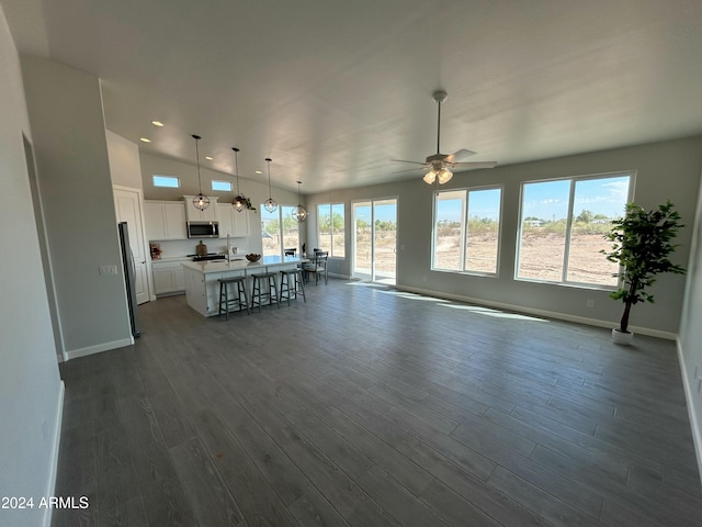 unfurnished living room with vaulted ceiling, ceiling fan, sink, and dark hardwood / wood-style floors