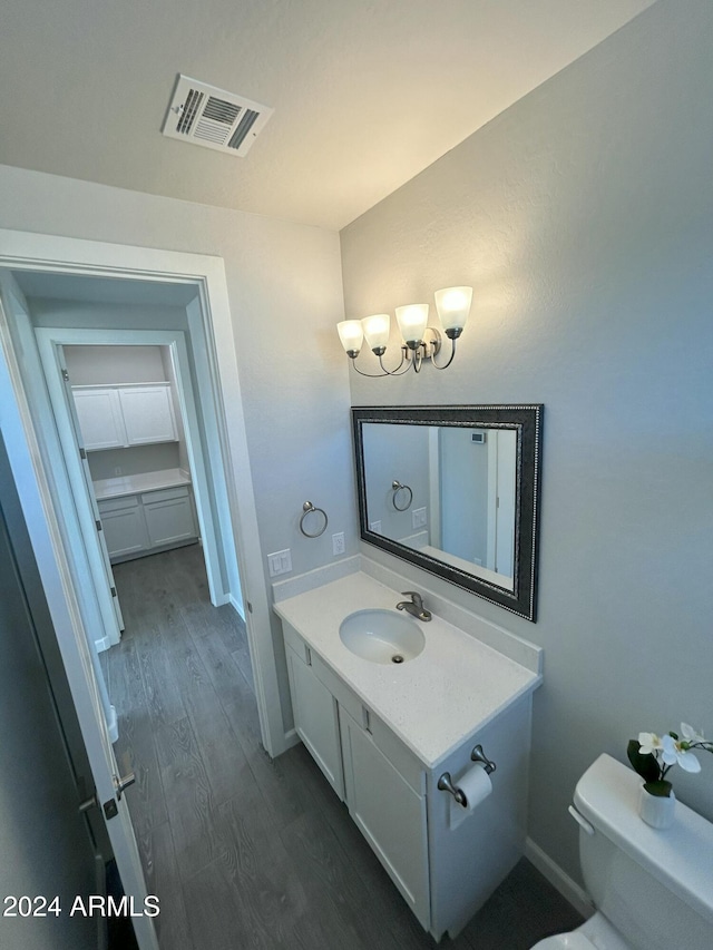 bathroom with hardwood / wood-style flooring, vanity, and toilet