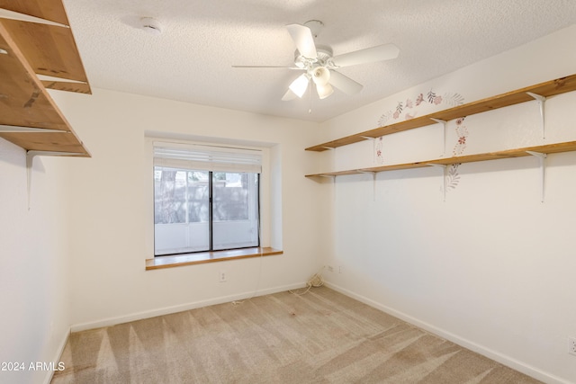 spacious closet featuring ceiling fan and light colored carpet