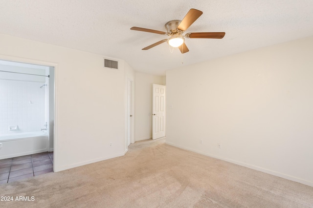 empty room with light carpet, a textured ceiling, and ceiling fan