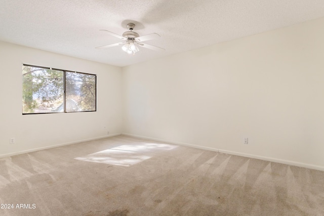 carpeted spare room with ceiling fan and a textured ceiling