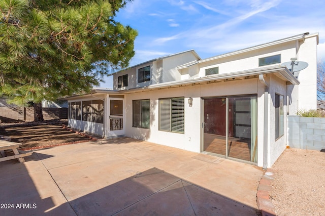 rear view of house with a sunroom and a patio