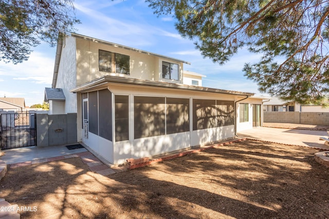 rear view of property with a sunroom and a patio