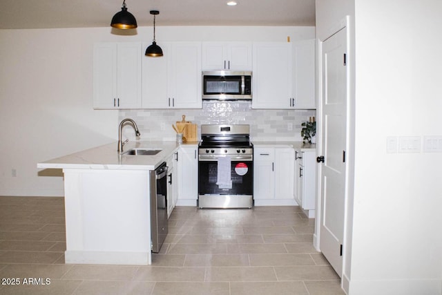 kitchen featuring stainless steel appliances, white cabinetry, sink, and decorative light fixtures