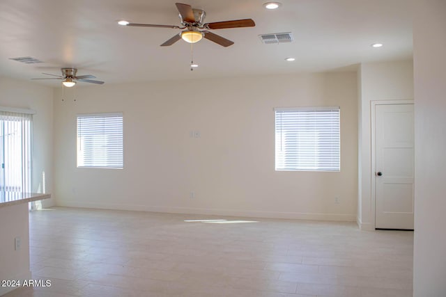 empty room with ceiling fan and light wood-type flooring