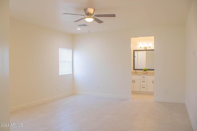 unfurnished bedroom with ensuite bathroom and ceiling fan