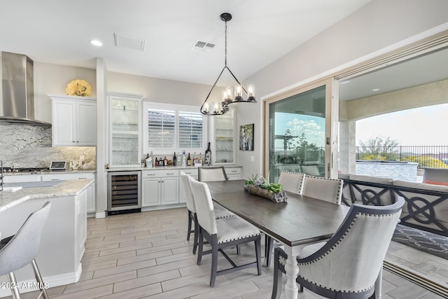 dining room with a chandelier, wine cooler, visible vents, and plenty of natural light