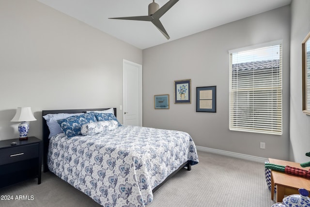 carpeted bedroom with ceiling fan and baseboards