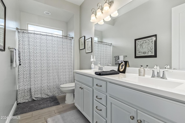 full bath featuring wood tiled floor, a notable chandelier, a sink, and toilet