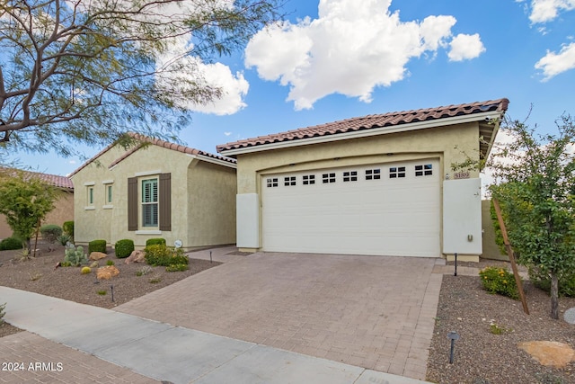 mediterranean / spanish house with a tiled roof, decorative driveway, and stucco siding