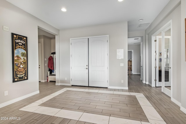 foyer entrance featuring wood tiled floor, visible vents, baseboards, and recessed lighting