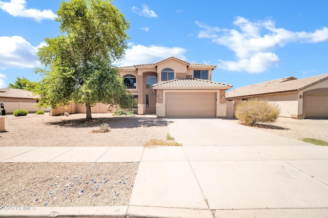 2605 W Darrel Rd, Phoenix, AZ 85041 - mediterranean / spanish-style home featuring stucco siding, driveway, an attached garage, and a tiled roof