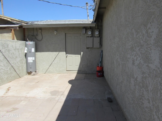 exterior space featuring stucco siding and electric water heater