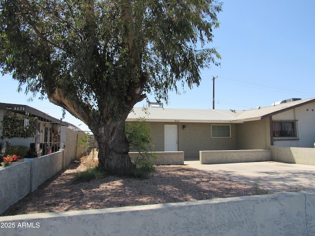ranch-style home with fence, a patio area, and stucco siding