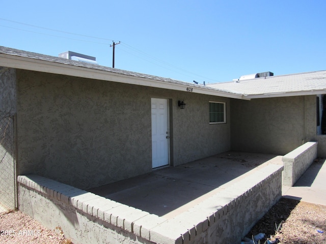 property entrance featuring a patio and stucco siding