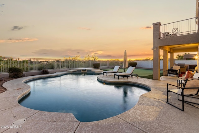 pool at dusk featuring a patio and a fenced backyard